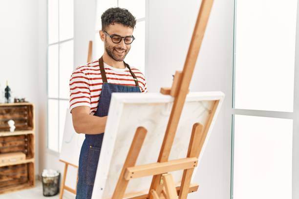 istock Young arab artist man smiling happy drawing at art studio. 1404422883