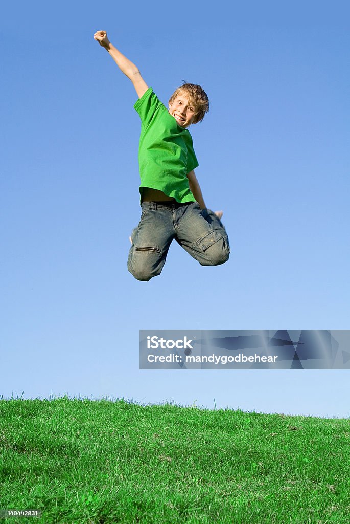 Feliz sorrindo criança de saltar de alegria com os braços para cima - Foto de stock de Alegria royalty-free