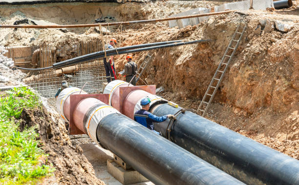 istock Construction works on large iron pipes at a depth of excavated trench 1404429020