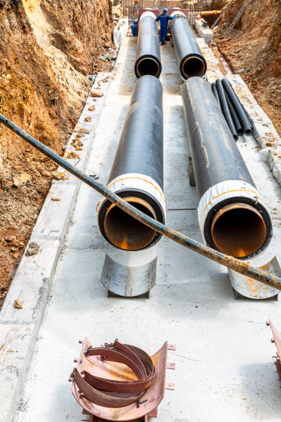 istock Construction works on large iron pipes at a depth of excavated trench 1404429025