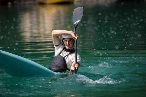 Young Man Practicing Kayaking in Soca River and Looking at Camera.