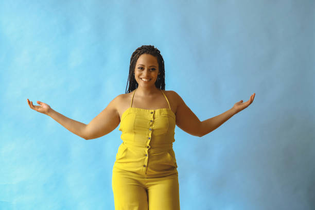 portrait of thankful happy young adult beautiful african american woman with braid hair posing at studio with hands open portrait of thankful happy young adult beautiful african american woman with braid hair posing at studio with hands open shot arms outstretched stock pictures, royalty-free photos & images