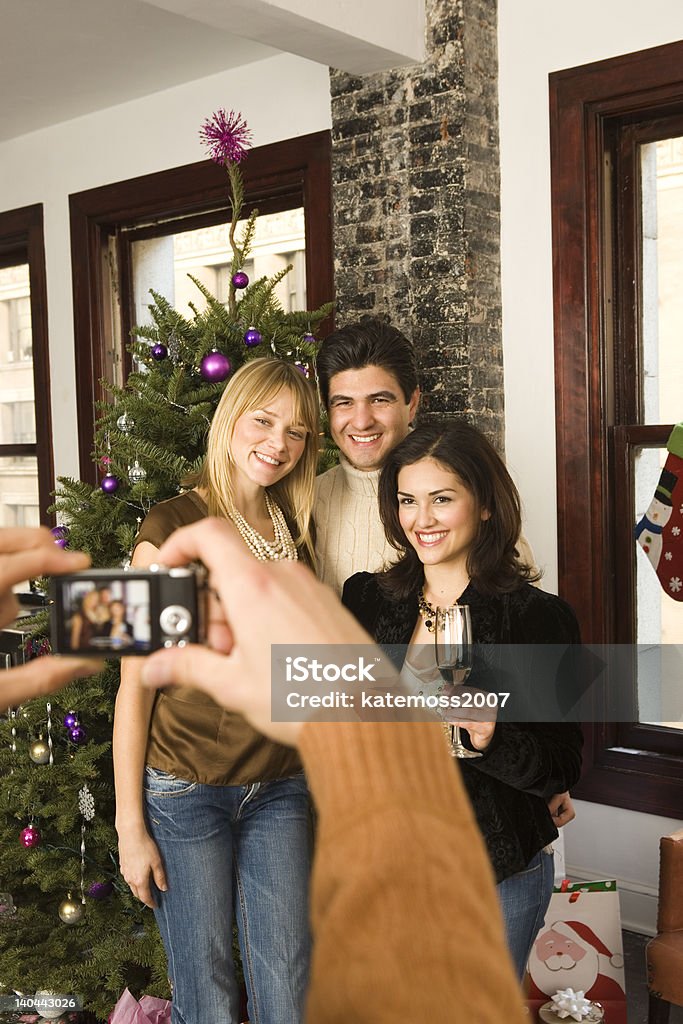 ご友人とご一緒にカメラに向かってポーズを取るのクリスマスパーティーのお祝い - 4人のロイヤリティフリーストックフォト