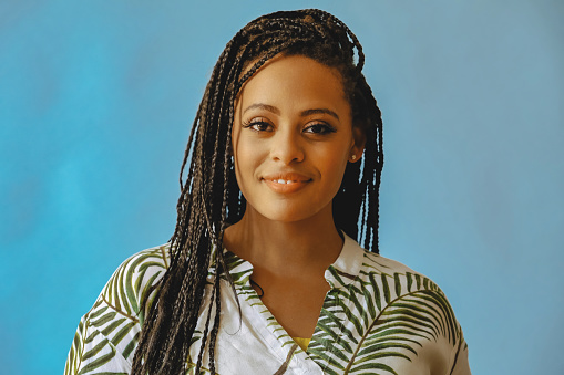 closeup portrait of smiling young beautiful african american woman braid hair posing at studio looking at camera shot