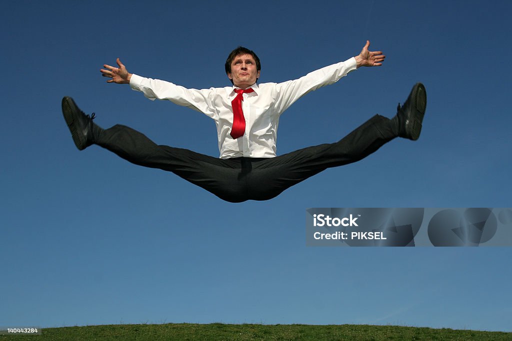 Hombre de negocios haciendo se divide en mid-air - Foto de stock de Abrise de piernas libre de derechos