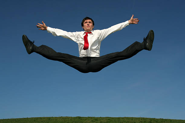 Businessman doing splits in mid-air