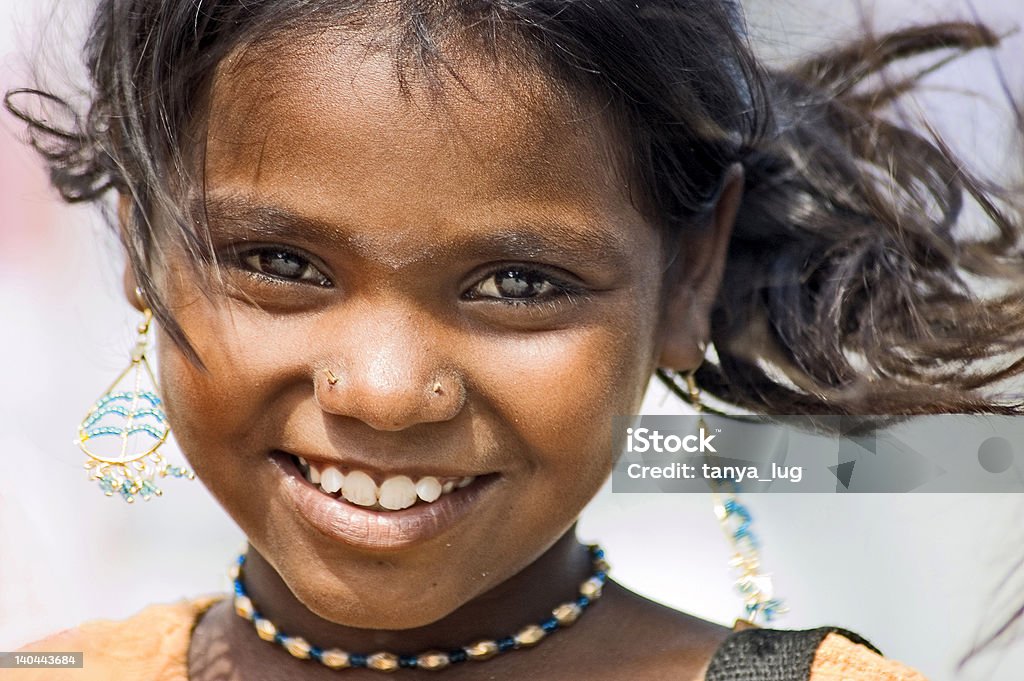 Indian girl wearing earring and hair blowing in the wind Portrait of a girl with earrings. Strong wind. Tamil Nadu/India. 8-9 Years Stock Photo