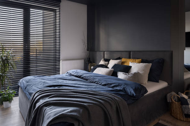Modern and comfortable bedroom Modern and comfortable bedroom with big window with blinds dark window blinds stock pictures, royalty-free photos & images