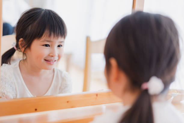 Girl looking at her face in the mirror
