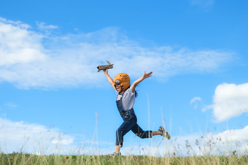 Photo of a little boy playing with an airplane toy at the beach