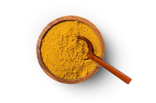 Turmeric powder (Curcuma longa linn) in wooden bowl with spoon isolated on white background, top view, flat lay, clipping path.