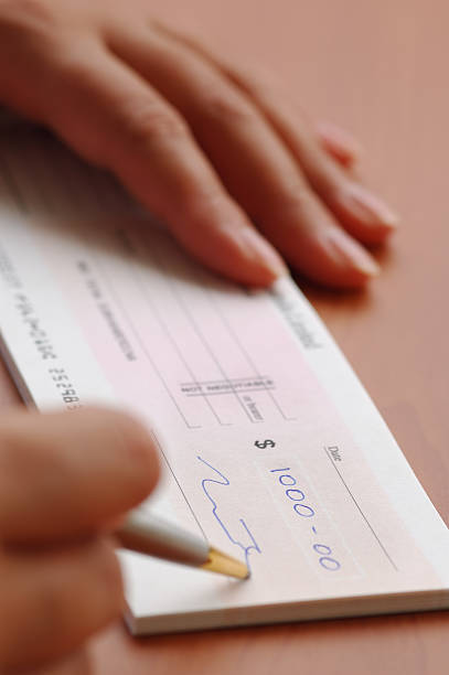 istock Signing a money cheque 140444406