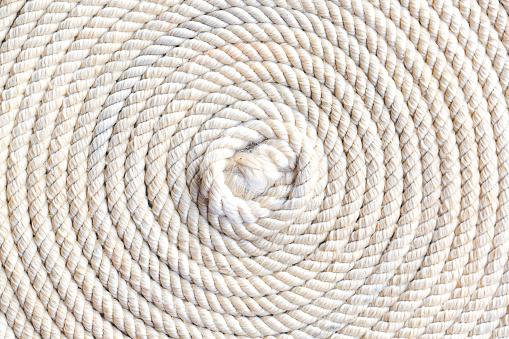 Macro rope texture,Super close up of a thick rope in shape of a spiral,Photo of an old vintage rope. Natural warm light