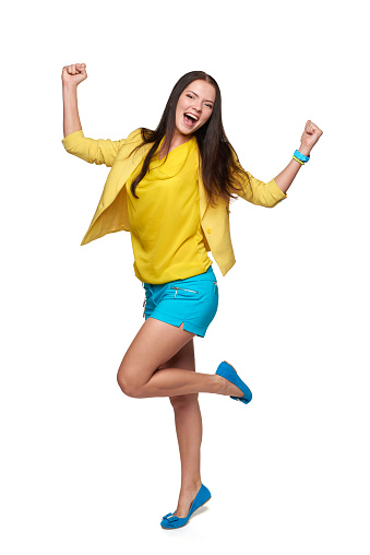 Full length of happy screaming girl in yellow and blue clothes celebrating success, isolated on white background