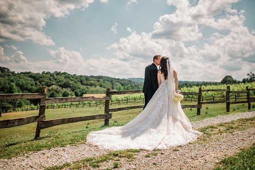 Gorgeous young couple enjoying in unforgettable wedding day surrounded with a beautiful nature. Summer countryside landscape at bright sunny day.
