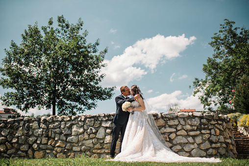 Gorgeous young couple enjoying in unforgettable wedding day surrounded with a beautiful nature. Summer countryside landscape at bright sunny day.