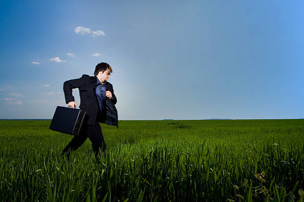istock Business man running on grass field 140444576
