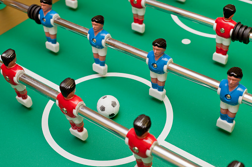 Table football, two teams will play the ball.