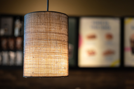 A lighting lamp with canvas fabric weave textured cover. Interior decoration object photo. Selective focus.