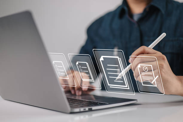 istock Paperless workplace ideas, e-signing, electronic signature, document management. A businessman uses a stylus pen to sign an electronic document that is on the screen of a virtual notebook. 1404453887