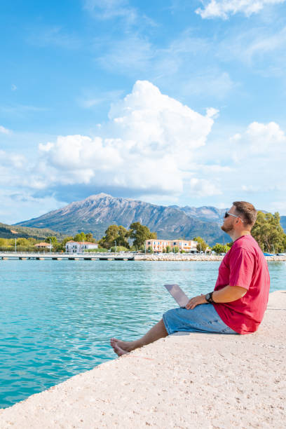 istock man freelancer working on laptop at city harbor bench 1404455108