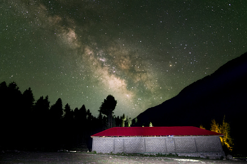 Milky way stars with light painting on red building in four ground.