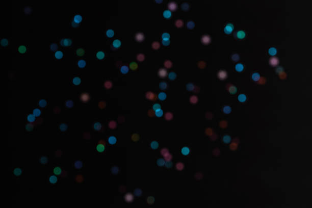 Black abstract bokeh festive background, texture. Colorful lights on black.