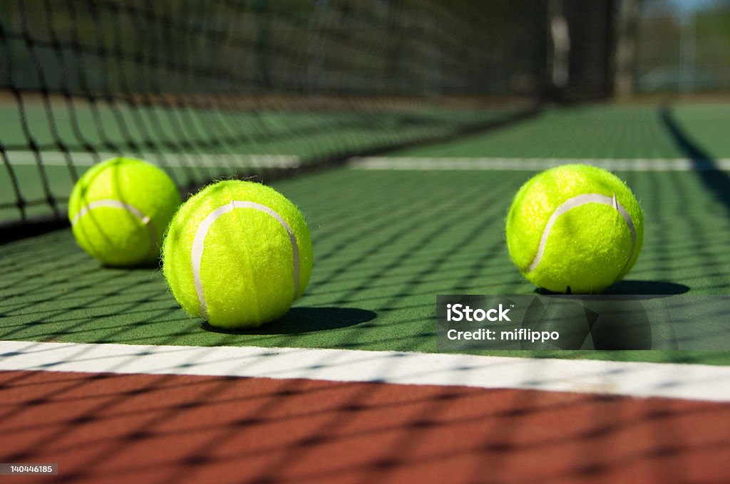 Tennis balls on Court Bright greenish, yellow tennis ball on freshly painted cement court Exercising Stock Photo