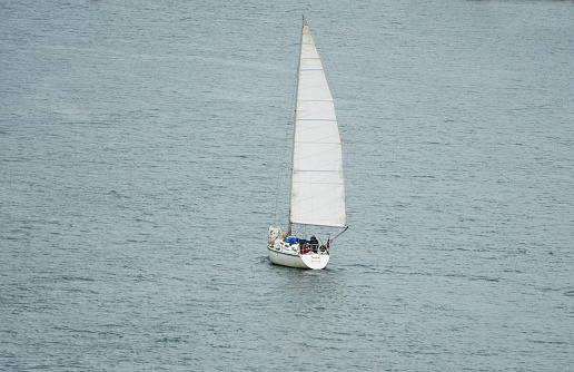 Small Sailboat or leisure Yacht sailing on calm seas. Full sails out.