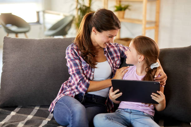istock Happy mom and little daughter relaxing using tablet together 1404462271