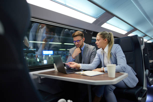 Business people traveling and working on the train using laptop stock photo