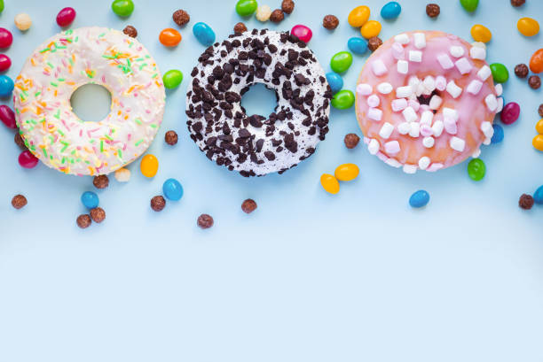 istock Set of different sweet glazed donuts with sprinkles and candy on blue background 1404464896