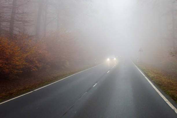 istock Autumnal road on a foggy day 1404468359