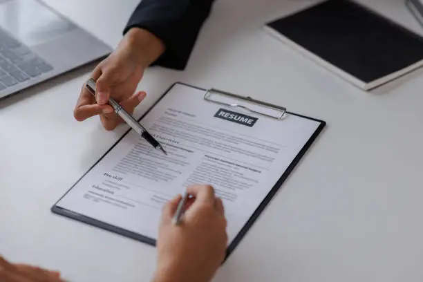 Photo of Examiner reading a resume during job interview at office Business and human resources concept.