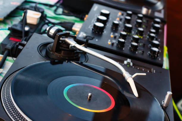 istock Vinyl record on a deejay's turntable with mixing desk equipment sound system 1404470992