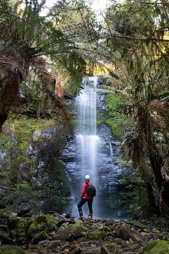 A woman contemplating a waterfall hidden on the mountains at the Serra Catarinense