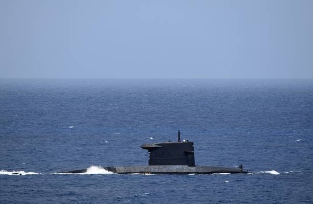 istock submarine partially submerged sails by on open water 1404472304