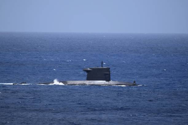 istock submarine partially submerged sails by on open water 1404472372