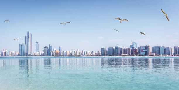 Panoramic view of Abu Dhabi Skyline UAE with skyscrapers and sea with seagulls stock photo