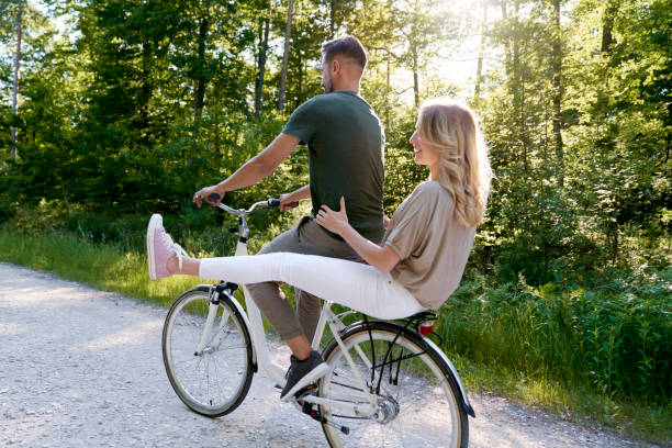 istock Happy Couple Sitting On Bicycle Against Trees 1404475811