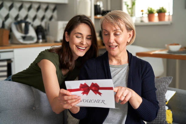 Daughter Giving Gift To Mother stock photo