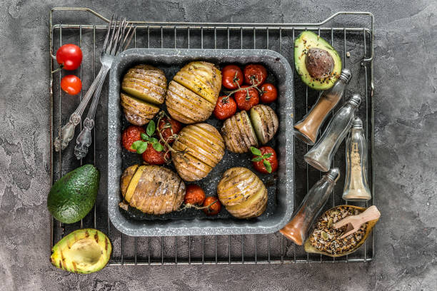 pommes de terre cuites au four sous forme de cuisson avec des légumes vue de dessus. - stove top photos et images de collection