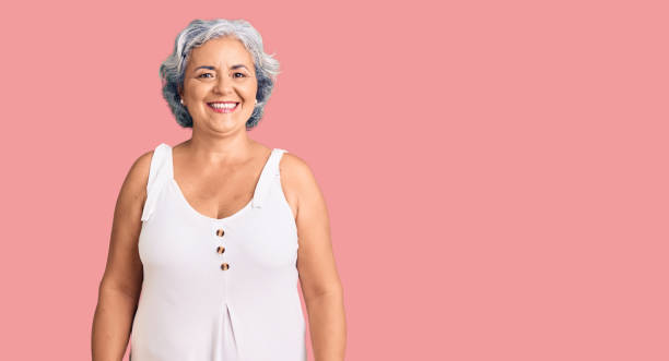 Senior woman with gray hair wearing casual clothes with a happy and cool smile on face. lucky person. stock photo