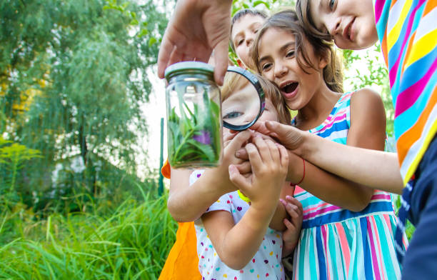 istock Kids Playing With Magnifying Glass In Garden 1404478083