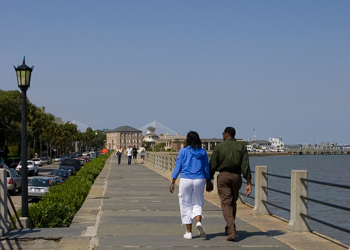 A couple strolls along the Waterfront in Charleston, South Carolina.