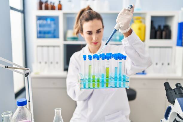 istock Young woman wearing scientist uniform using pipette working at laboratory 1404480904