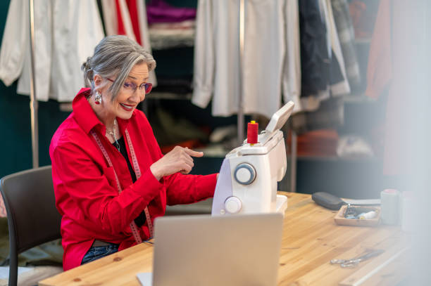 istock Woman looking at laptop pointing at sewing machine 1404481999
