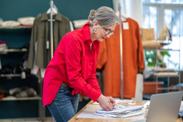 istock Woman standing sideways to camera packing clothes 1404482055