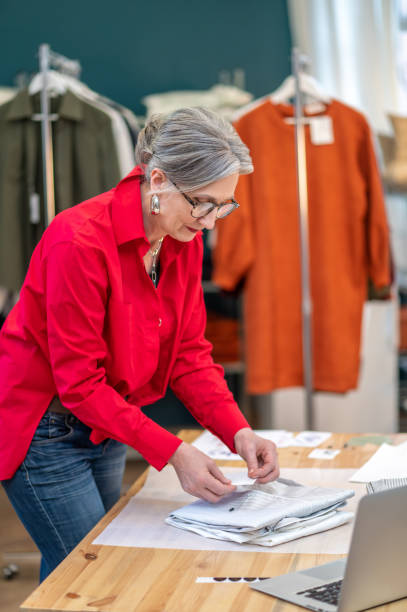 istock Woman touching clothes standing near table 1404482056