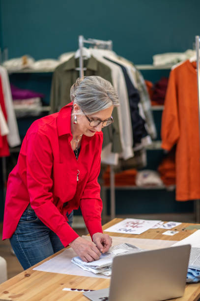 istock Woman carefully packing clothes bent over table 1404482062